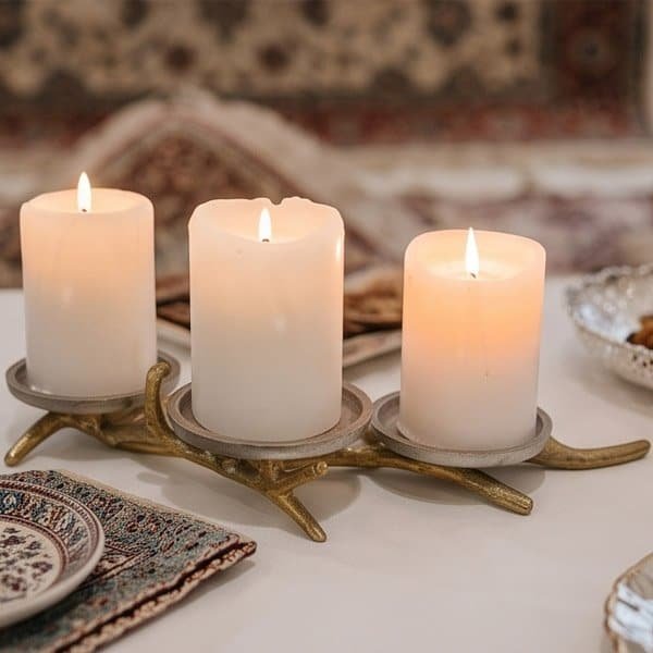 Decorative branch candle holder with three lit candles for cozy ambiance.