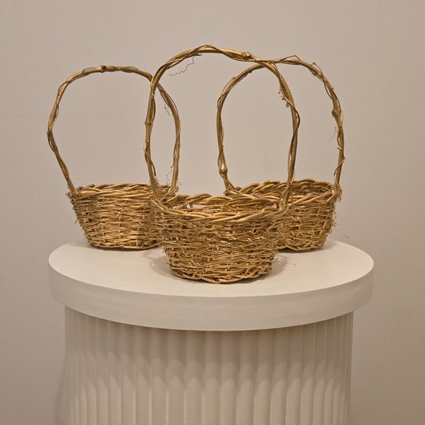 A set of three Gold Confetti Baskets with whimsical vine handles, shown displayed as an elegant decor option for a wedding ceremony.