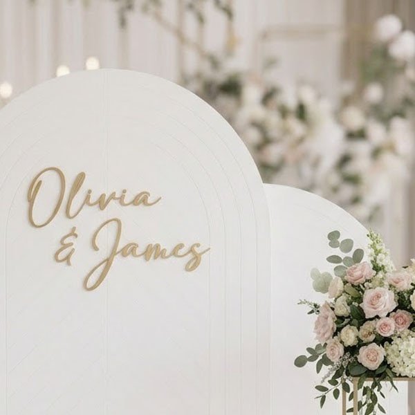Elegant wedding backdrop with floral arrangements and personalized names Olivia & James.
