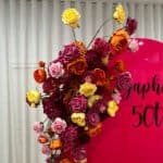Vibrant floral backdrop with roses in pink, yellow, orange, and purple for celebrations.
