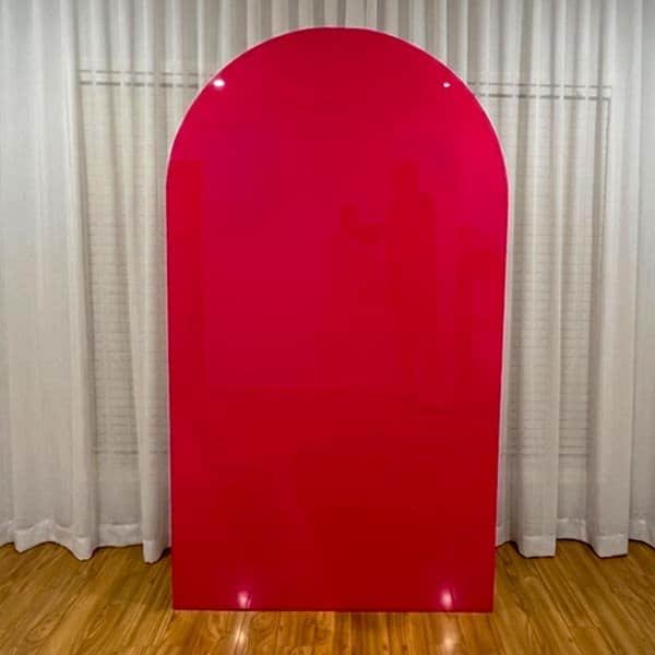 Vibrant red custom backdrop standing in front of white curtains.
