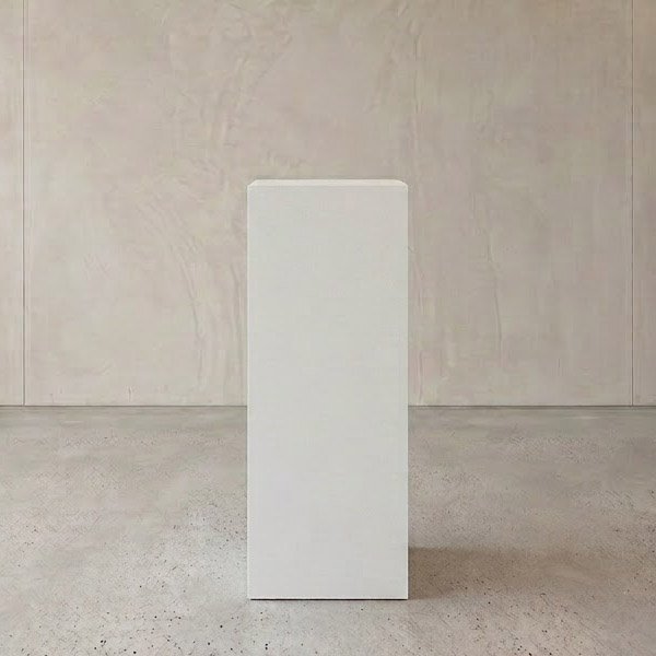 White pedestal display stand in modern interior setting for decor or product showcase.
